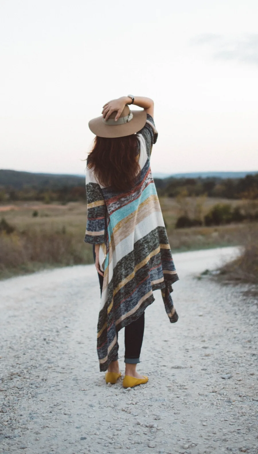 Stephanie, founder of The Wild Moon Company, on a path holding her hat